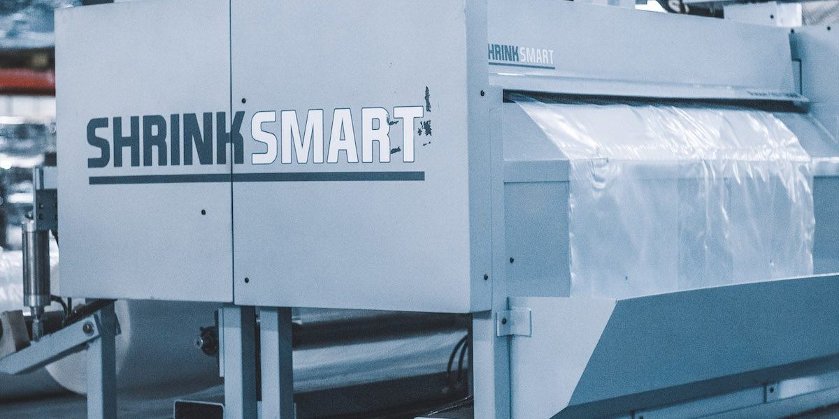 The Shrink Smart bagging automation equipment cuts and perforates a bag that will be used to wrap furniture for shipment.