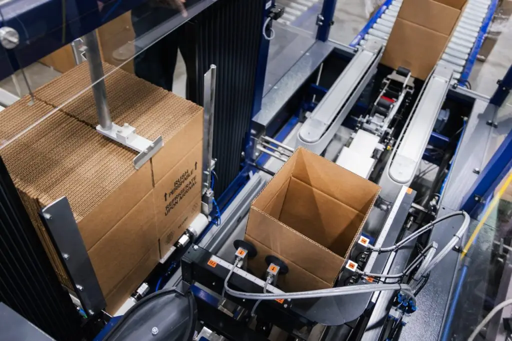 Automated packaging line erecting and conveying corrugated cardboard boxes at Morrisette Packaging